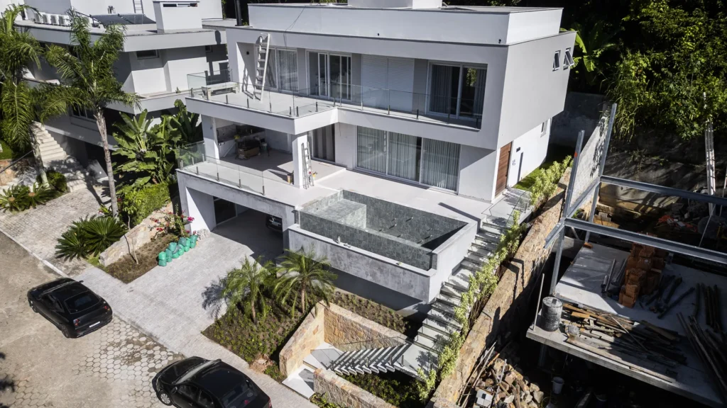 Casa C/K, no Canajurê, vista de drone com a rua e a vegetação ao redor
